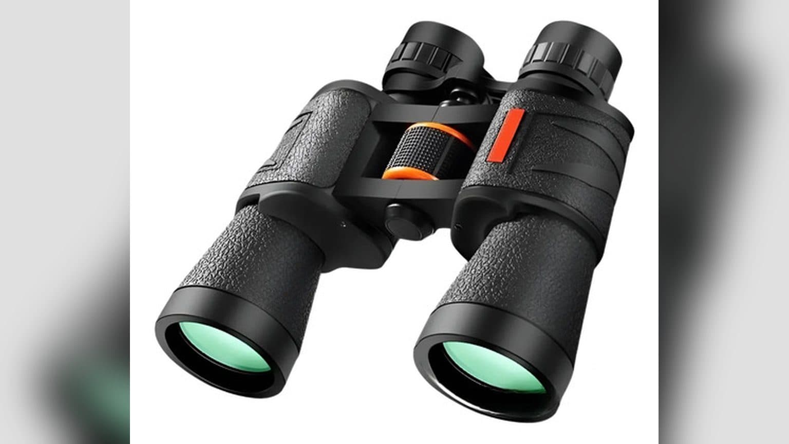 Binoculares 8x20 HD BAK4 Waterproof FMC de Novystor sobre una mesa de madera junto a su correa de transporte y paño de limpieza, con un paisaje de fondo desenfocado.