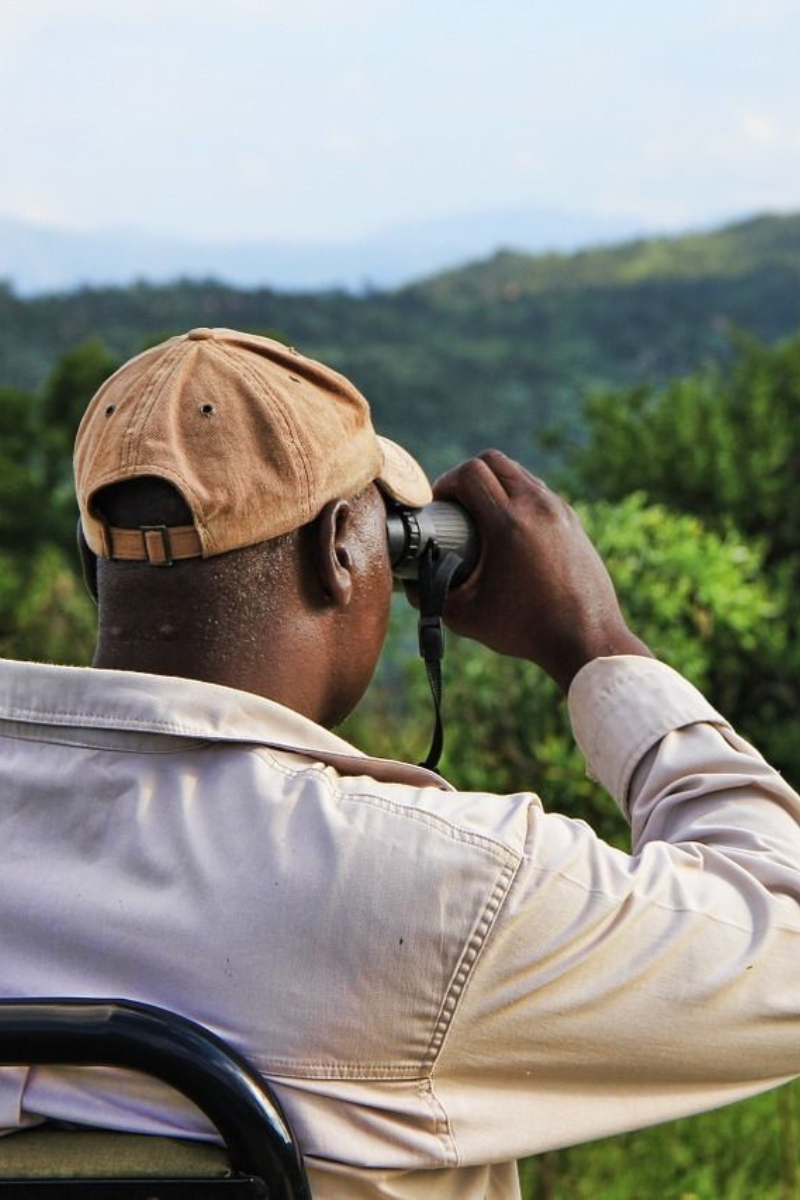 Persona utilizando binocular para observar el paisaje